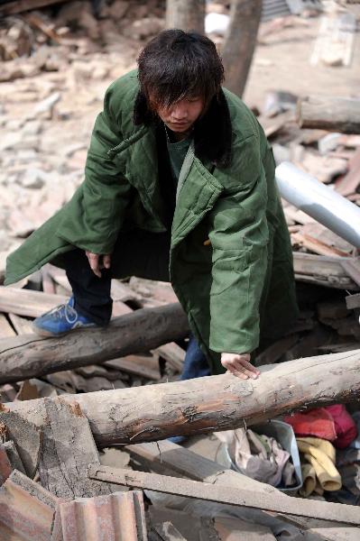Yang Yang, a 23-year-old young man who saved seven lives from the quake debris, shows the house that witnessed his heroism in Gyegu, northwest China's Qinghai Province, April 17, 2010.