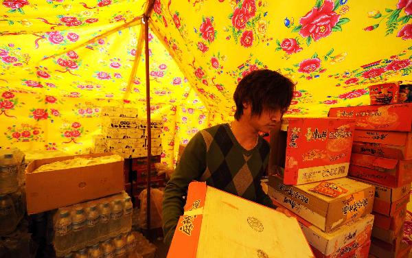 Yang Yang, a 23-year-old young man who saved seven lives from the quake debris, returned to the makeshift dining room to cook for his colleagues in Gyegu, northwest China's Qinghai Province, April 17, 2010.