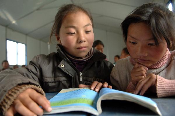 A Grade Two student (L, Front) of the Yushu School for Orphans has a lesson when resuming classes in Gyegu Town, northwest China's Qinghai Province, on April 17, 2010. 