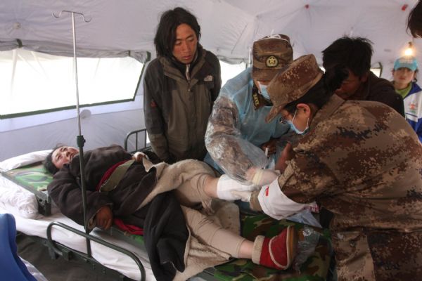 An injured Tibetan ethnic woman receives medical treatment at a military tent at quake-hit Yushu county, northwest China's Qinghai Province, April 17, 2010. 
