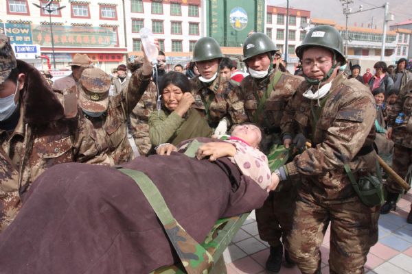 A group of Chinese military medics carry an injured woman to a military tent at quake-hit Yushu county, northwest China's Qinghai Province, April 17, 2010. 