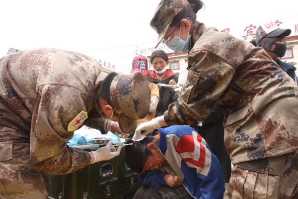 An injured Tibetan ethnic boy receives medical treatment at a military tent at quake-hit Yushu county, northwest China's Qinghai Province, April 17, 2010. 