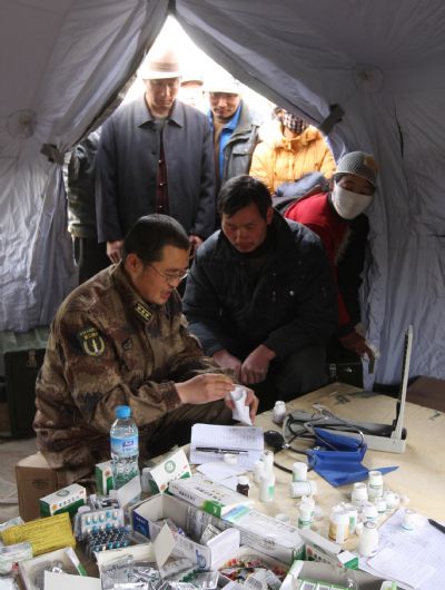 A Chinese military medical officer gives the injured medical treatment at a military tent at quake-hit Yushu county, northwest China's Qinghai Province, April 17, 2010. 
