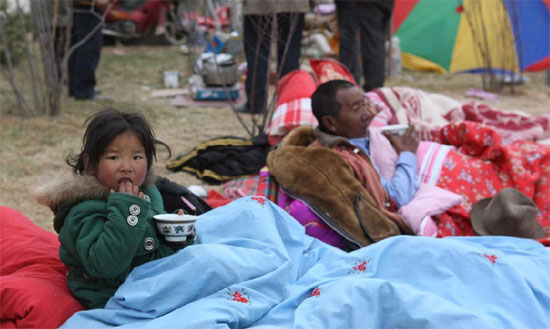 A young quake victim rests with a meal in Yushu Tibetan Autonomous Prefecture in Qinghai that was hit by a 7.1-magnitude earthquake early on Wednesday.
