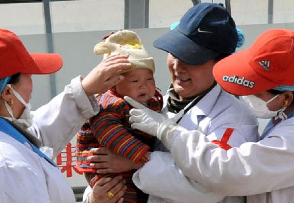 Medical staff of a medical team tease a baby in the Tibetan Autonomous Prefecture of Yushu, northwest China's Qinghai Province, April 18, 2010.