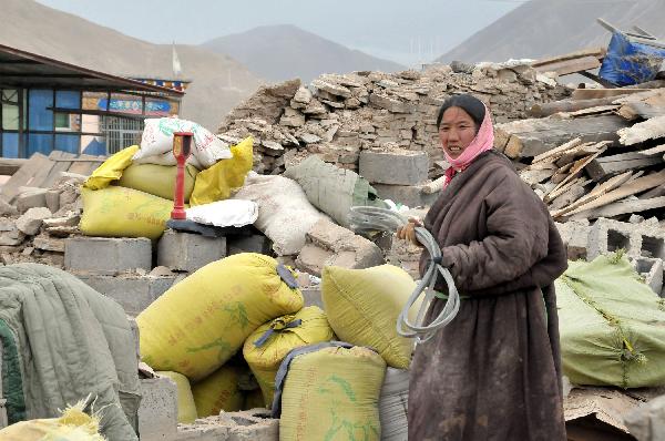 A woman collects her belongs in Gyegu Town, the quake-hit Tibetan Autonomous Prefecture of Yushu, in northwest China&apos;s Qinghai Province, April 17, 2010. The 7.1-magnitude earthquake that struck Yushu of Qinghai Province, left 1,484 dead and 312 still missing, and about 100,000 people were relocated. 