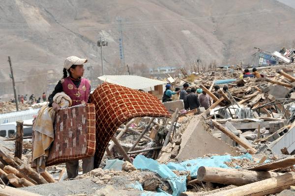 The elder daughter of Ngot (transliterated) looks for belongings on the debris of their home in Gyegu Town of the Tibetan Autonomous Prefecture of Yushu, northwest China&apos;s Qinghai Province, April 17, 2010. Ngot, a 45-year-old man living in Gyegu Town, lost his wife in the fatal earthquake that struck here early Wednesday. He planned to do business in the future to raise his six daughters, aged from one and a half to 15.