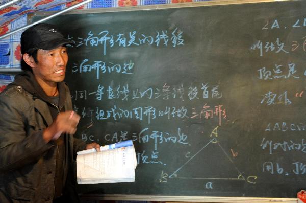 A teacher of the Tibetan ethnic group conducts a class at the No. 1 High School for Nationalities of the quake-hit Tibetan Autonomous Prefecture of Yushu, northwest China's Qinghai Province, April 18, 2010. The school resumed its classes on Sunday. A 7.1-magnitude quake struck Yushu Wednesday morning.