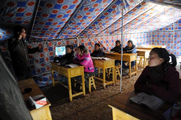 High school students attend class inside a tent which is used as a classroom of the No. 1 High School for Nationalities of the quake-hit Tibetan Autonomous Prefecture of Yushu, northwest China's Qinghai Province, April 18, 2010. The school resumed its classes on Sunday. A 7.1-magnitude quake struck Yushu Wednesday morning.