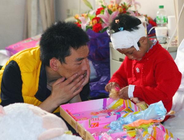 A volunteer (L) plays with an injured child at the 1st affiliated hospital of Xi&apos;an Jiaotong University in Xi&apos;an, northwest China&apos;s Shannxi province, April 18, 2010. Many volunteers of the Tibetan ethnic group supplied oral interpretation service in hospitals in Xi&apos;an, where injured people from the quake-hit Yushu Tibetan Autonomous Prefecture of northwest China&apos;s Qinghai Province are treated.