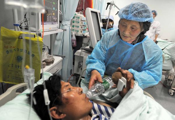 Tibetan volunteer Cering feeds water to an injured at the Huaxi Hospital Affiliated to Sichuan University in Chengdu, southwest China&apos;s Sichuan Province, April 18, 2010. Cering came from Ganzi Tibetan Autonomous Prefecture of Sichuan Province to the hospital and offered assistance to the injured people.