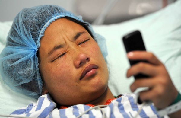 Qiuqu injured in the quake makes phonecall to their parents after meets her seriouly-injured brother Gajiao at the Huaxi Hospital Affiliated to Sichuan University in Chengdu, southwest China&apos;s Sichuan Province, April 18, 2010. Nine-year-old Gajiao and his elder sister Qiuqu were transfered to the hospital after they were injured in the 7.1-magnitude earthquake. 