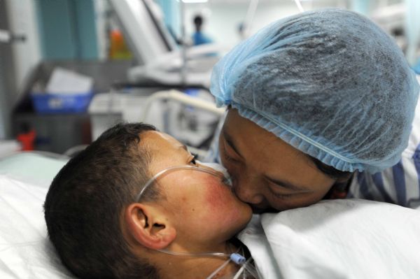 Injured Qiuqu kisses her younger brother Gajiao when they meet for the first time after transfered from the quake-hit site for medical treatment at the Huaxi Hospital Affiliated to Sichuan University in Chengdu, southwest China&apos;s Sichuan Province, April 18, 2010. Nine-year-old Gajiao and his elder sister Qiuqu were transfered to the hospital after they were injured in the 7.1-magnitude earthquake.