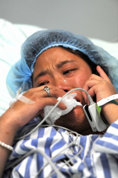 Qiuqu makes phonecall to her parents after meets with her seriouly-injured brother Gajiao at the Huaxi Hospital Affiliated to Sichuan University in Chengdu, southwest China&apos;s Sichuan Province, April 18, 2010. Nine-year-old Gajiao and his elder sister Qiuqu were transfered to the hospital after they were injured in the 7.1-magnitude earthquake.