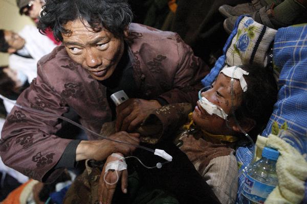 Cewn Degyi (R) rests in an aircraft heading to Xining for treat in Yushu, northwest China's Qinghai Province, April 19, 2010. Civil aircrafts and military planes were put into operation for rescue team and supply transportation after the quake hit Yushu County.