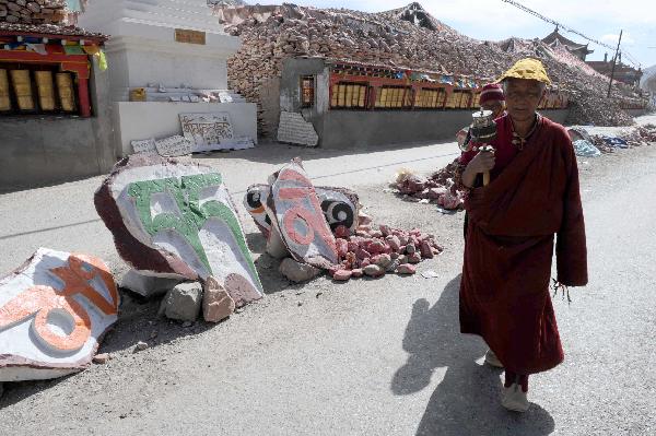 A circumanbulator walks by the destroyed Gyanak Marnyi stones, about 2 kilometers from the quake-hit Gyegu Town of Yushu Tibetan Autonomous Prefecture of northwest China's Qinghai Province, April 19, 2010. The earthquake on April 14 also devastated Gyanak Marnyi stones, the biggest pile of marnyi stones in the world.