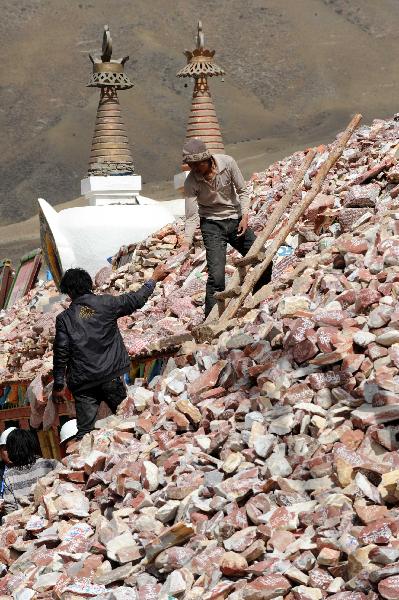 Two local people refit the destroyed Gyanak Marnyi stones, about 2 kilometers from the quake-hit Gyegu Town of Yushu Tibetan Autonomous Prefecture of northwest China's Qinghai Province, April 19, 2010. 