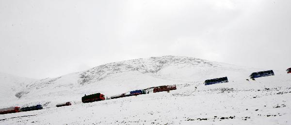 A long fleet of cargo vehicles transports quake-relief materials to Yushu, northwest China's Qinghai Province, April 19, 2010. The quake-relief materials were continuously transported to the disaster areas despite the snowfall and frozen road surface.