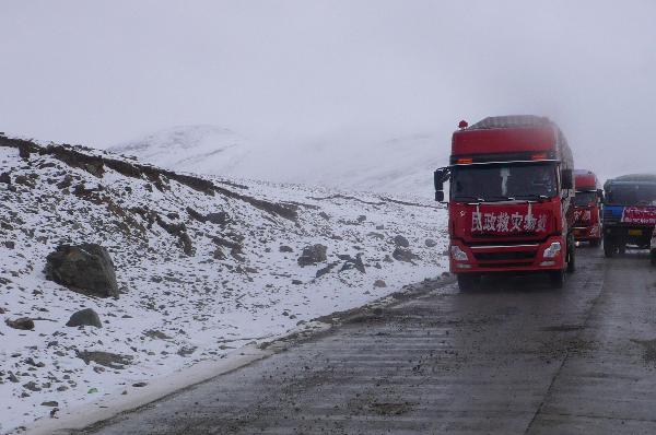 Running on the snow-covered plateau, a long motorcade of cargo vehicles transport quake-relief materials to Yushu, northwest China's Qinghai Province, April 19, 2010. The quake-relief materials were continuously transported to the disaster areas despite the snowfall and frozen road surface.