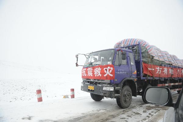 A truck of a long fleet of cargo vehicles transports quake-relief materials to Yushu, northwest China's Qinghai Province, April 19, 2010. The quake-relief materials were continuously transported to the disaster areas despite the snowfall and frozen road surface.