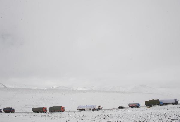 A long fleet of cargo vehicles transports quake-relief materials to Yushu, northwest China's Qinghai Province, April 19, 2010. The quake-relief materials were continuously transported to the disaster areas despite the snowfall and frozen road surface.