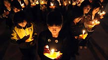Students at Nankai University in Tianjin municipality hold a candlelight vigil in memory of Yushu earthquake victims on Tuesday, April 20, 2010.