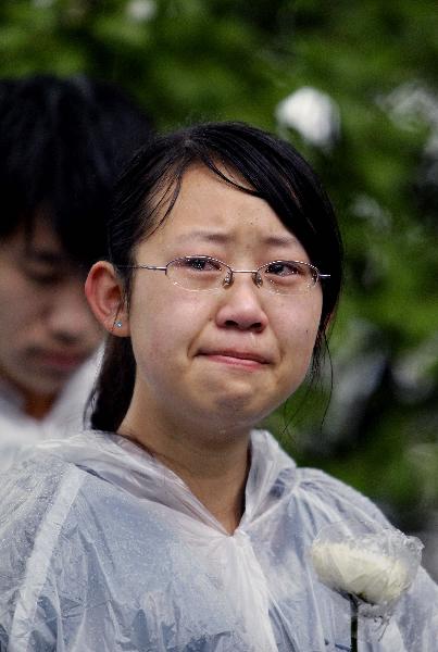 A student of Fudan University weeps for the victims of Yushu earthquake during a mourning ceremony in Shanghai, east China, April 21, 2010.