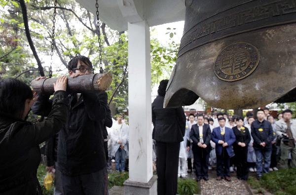 Students of Fudan University ring a bell to pay respect to the victims of Yushu earthquake during a mourning ceremony in Shanghai, east China, April 21, 2010.