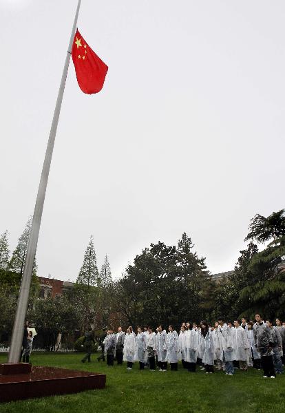 Students of Fudan University ring a bell to pay respect to the victims of Yushu earthquake during a mourning ceremony in Shanghai, east China, April 21, 2010.