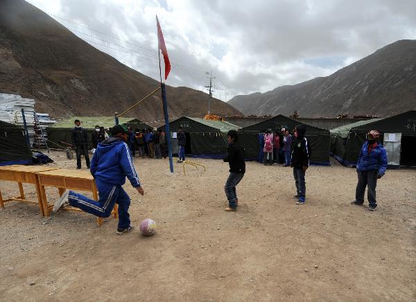 Students play ball outside tents which are used as classrooms in Yushu, northwest China's Qinghai Province, April 20, 2010. 