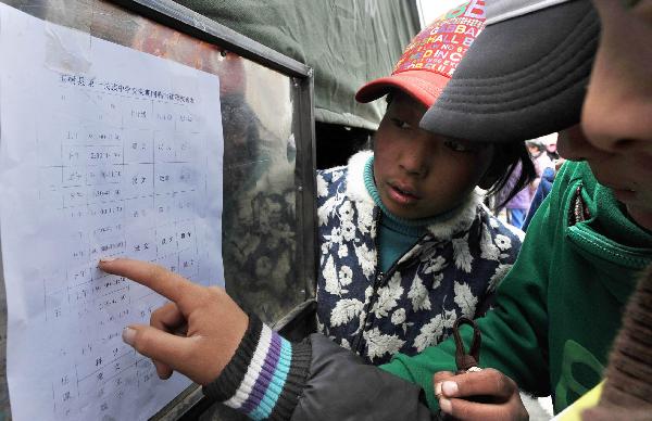 Students check their temporary class schedule in Yushu, northwest China's Qinghai Province, April 20, 2010. 