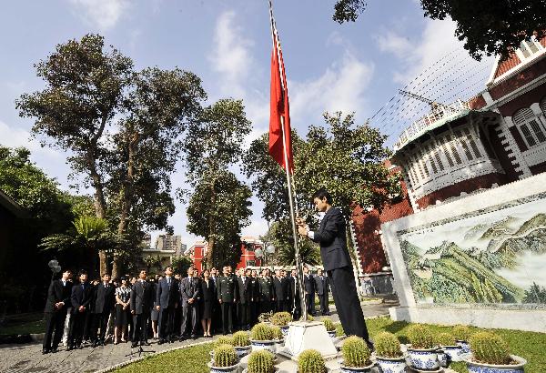 A staff member of the Chinese Embassy to Egypt lowers the Chinese national flag to half mast as others mourn for the victims of Yushu earthquake in northwest China, at the embassy in Cario, capital of Egypt, April 21, 2010.