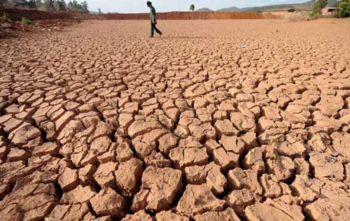 A man walks through a dried-up reservoir in the drought-hit Donghua county of Chuxiong City, Southwest China's Yunnan Province, April 21, 2010.