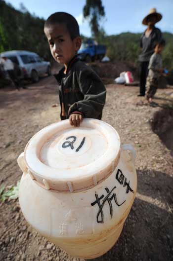 A Yi ethnic boy waits for water-loaded trucks in the drought-hit Donghua county of Chuxiong City, southwest China's Yunnan Province, April 21, 2010