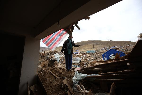 A woman is showing the place where her elder brother was stuck and buried in the quake on April 21, 2010. 