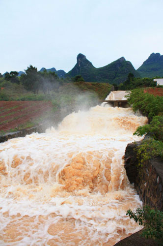 Triggered by torrential rain over the past few days, a raging torrent swept through Gongcheng Autonomous Prefecture in Guangxi, April 22, 2010. 