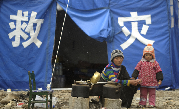 A mother accompanies her child outside a tent in quake-hit Yushu County, northwest China's Qinghai Province, April 22, 2010.