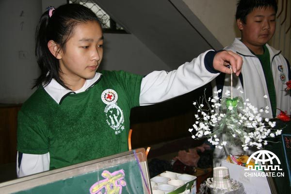A girl shows an ornament made from a plastic bottle and some plastic foam at an Earth Day activity on April 22, 2010.