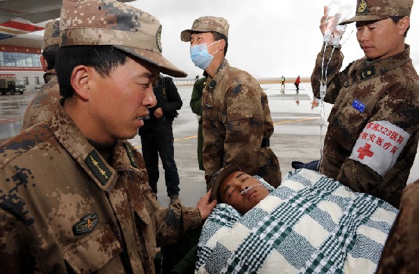 Rescuers carry an injured to an aircraft at an airport in quake-hit Yushu County, northwest China&apos;s Qinghai Province, April 22, 2010. 