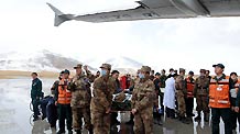 Rescuers carry an injured to an aircraft at an airport in quake-hit Yushu County, northwest China's Qinghai Province, April 22, 2010.