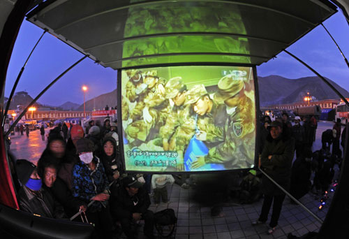 People gather at Gyegu's King Gesar Square to watch TV programs in the Tibetan language in Gyegu township, epicenter of the 7.1-magnitude quake, Qinghai Province, April 22, 2010. 