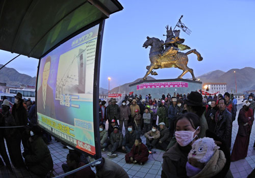 People gather at Gyegu's King Gesar Square to watch TV programs in the Tibetan language in Gyegu township, epicenter of the 7.1-magnitude quake, Qinghai Province, April 22, 2010.