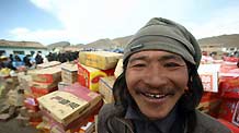 A villager smiles when he receives relief supplies in Longbao County, Qinghai province, April 22, 2010.