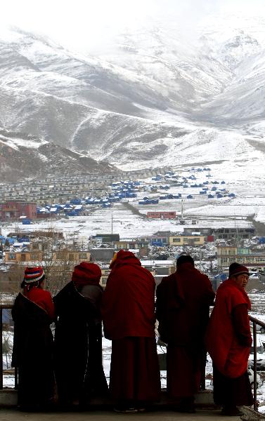 Lamas look at the tent area in the quake-hit Tibetan Autonomous Prefecture of Yushu, northwest China's Qinghai Province, April 22, 2010. 