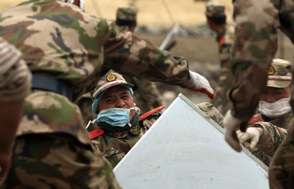Soldiers help local people transport properties found in the debris in the quake-hit Tibetan Autonomous Prefecture of Yushu, northwest China's Qinghai Province, April 22, 2010. 