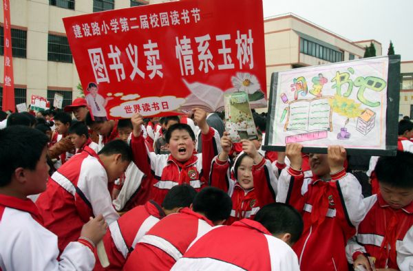 Pupils put their books and reading materials in a charity bazaar, to raise money for the quake-hit areas in Yushu of Qinghai, on campus of Jianshelu Elementary School, in Zaozhuang City, east China's Shandong Province, April 22, 2010. 