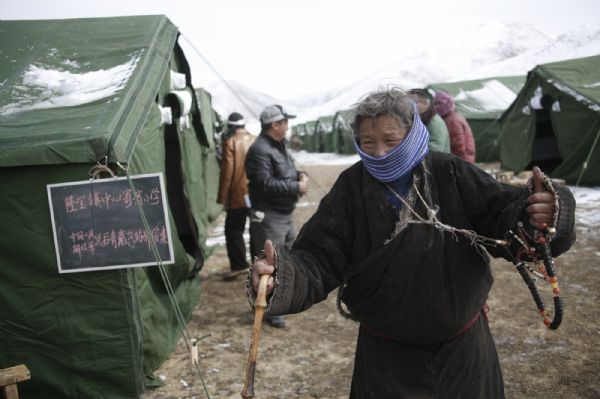 An elder leaves after sending her grandson to a tent school in Longbao Town of the quake-hit Tibetan Autonomous Prefecture of Yushu, northwest China's Qinghai Province, April 22, 2010.