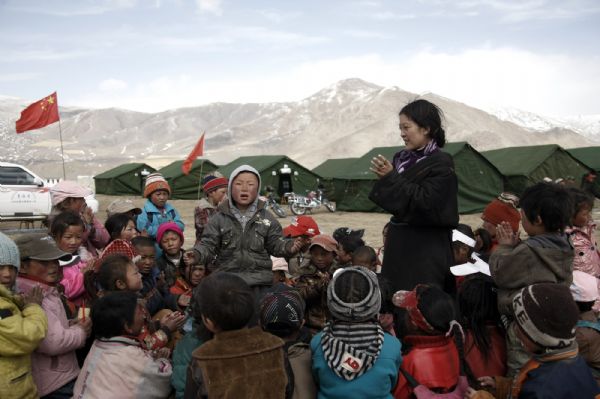 A local kid sings songs at a tent school in Longbao Town of the quake-hit Tibetan Autonomous Prefecture of Yushu, northwest China's Qinghai Province, April 22, 2010.