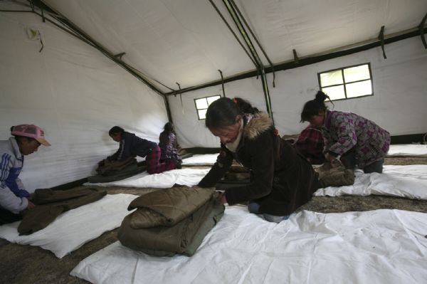 Local kids tidy at a tent school in Longbao Town of the quake-hit Tibetan Autonomous Prefecture of Yushu, northwest China's Qinghai Province, April 22, 2010. 