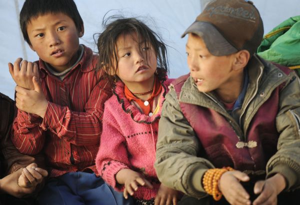 Children of Tibetan ethnic group have their classes inside the temporary classroom at racecourse Gyegu Town of quake-hit Tibetan Autonomous Prefecture of Yushu, northwest China's Qinghai Province, April 25, 2010. 